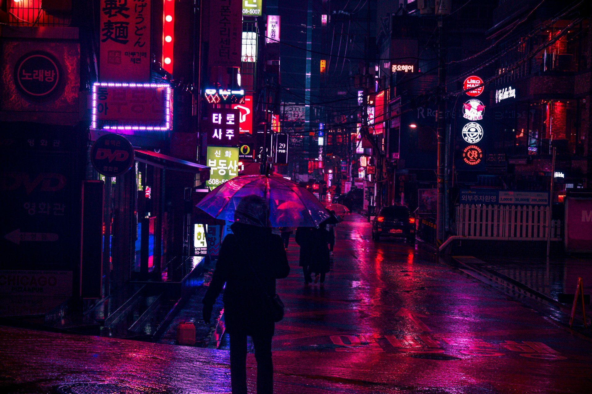 A Seoul street at night, lit in blue and pink neon (illustrative photo)